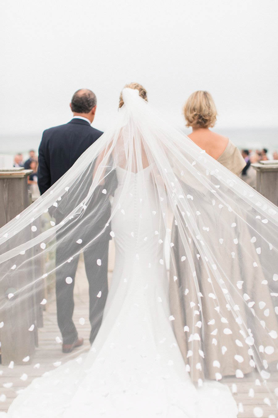 Bride walks down aisle at Hamptons beach wedding in photo by NYC photographer Amy Rizzuto.