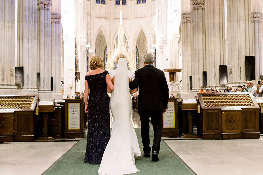 Margaret walks down the aisle with her parents at her St. Patrick's Cathedral wedding ceremony in this photo by NYC wedding photographer Amy Rizzuto.