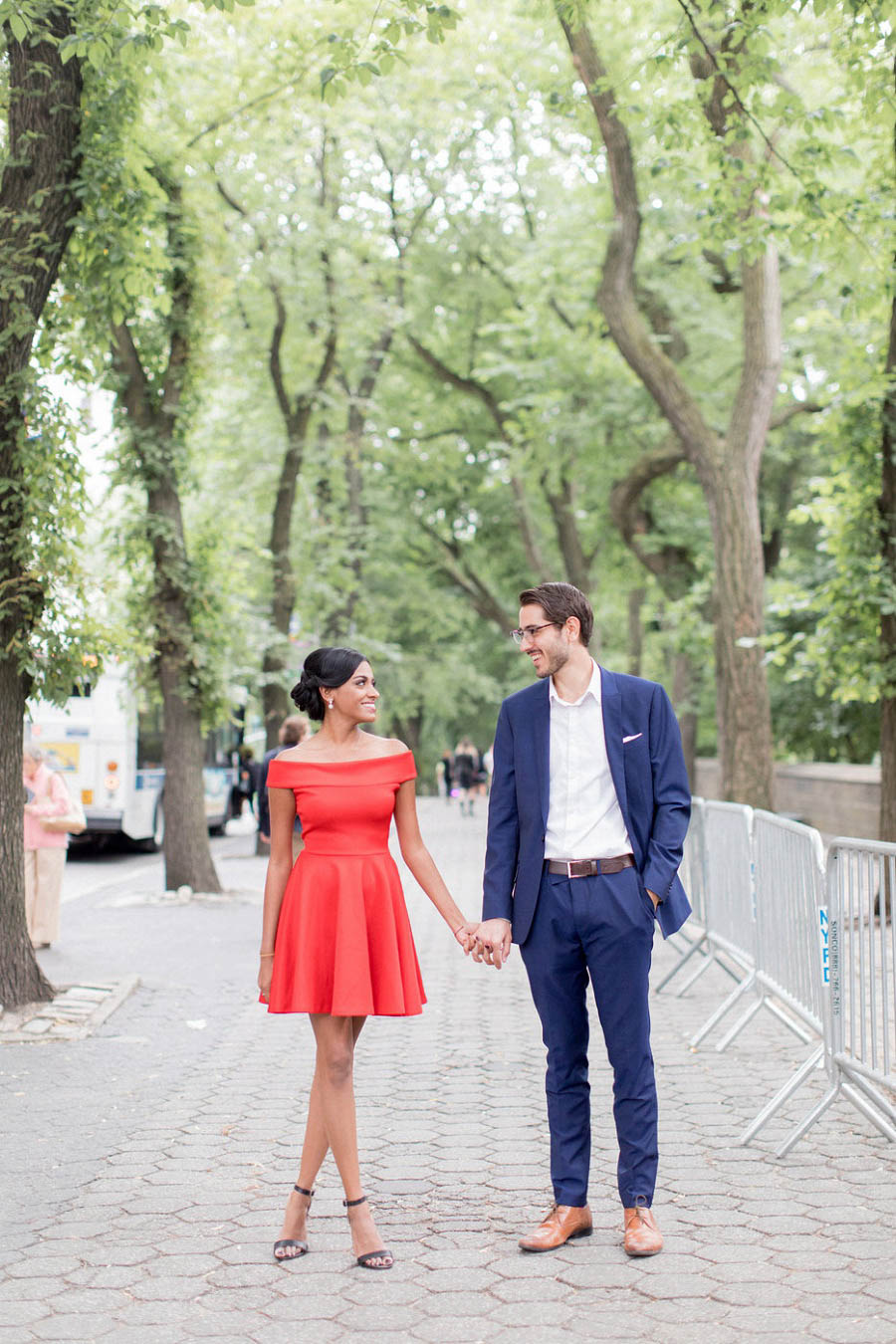 Couple poses on the sidewalk outside of Central Park in this Central Park engagement photo by NYC wedding photographer Amy Rizzuto