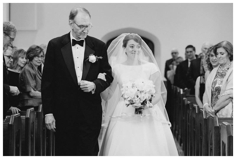 Bride emotional walking down aisle with father on wedding day
