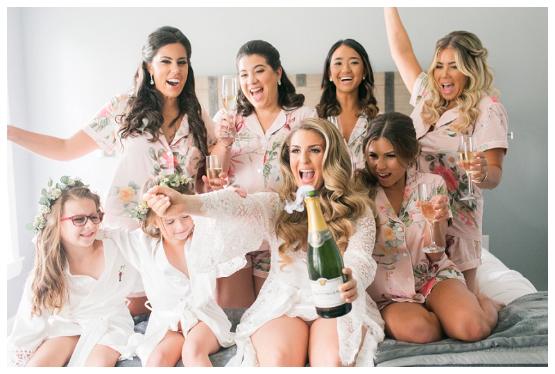 bride popping champagne with bridesmaids at the ryland inn wedding