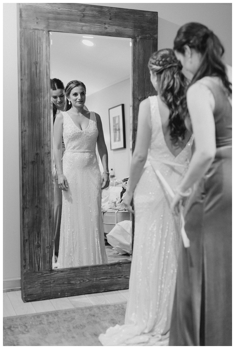 Bride putting on wedding dress black and white photo