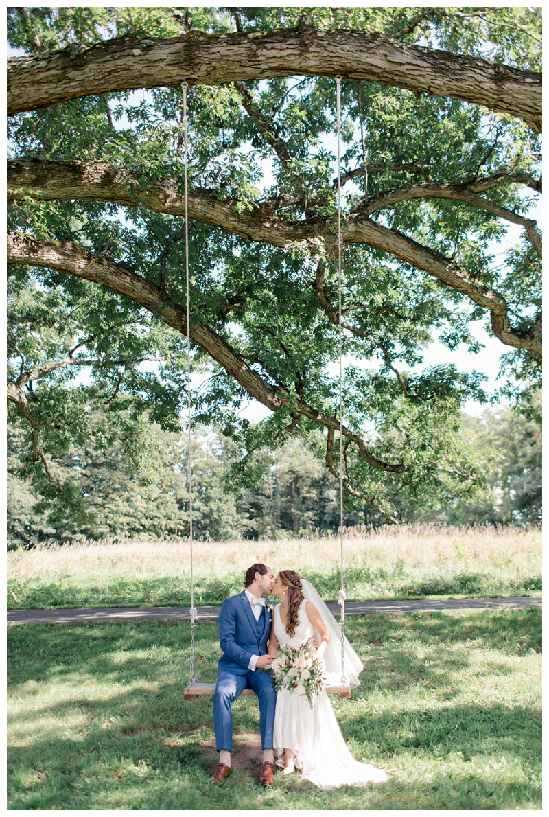 bride and groom kiss on swing photo at Red Maple Vineyard wedding