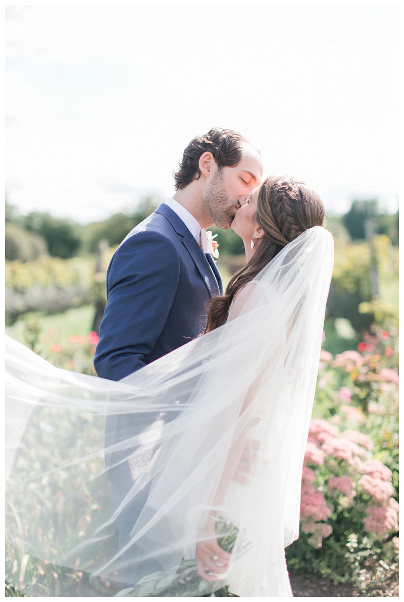 bride and groom kissing with veil photo idea