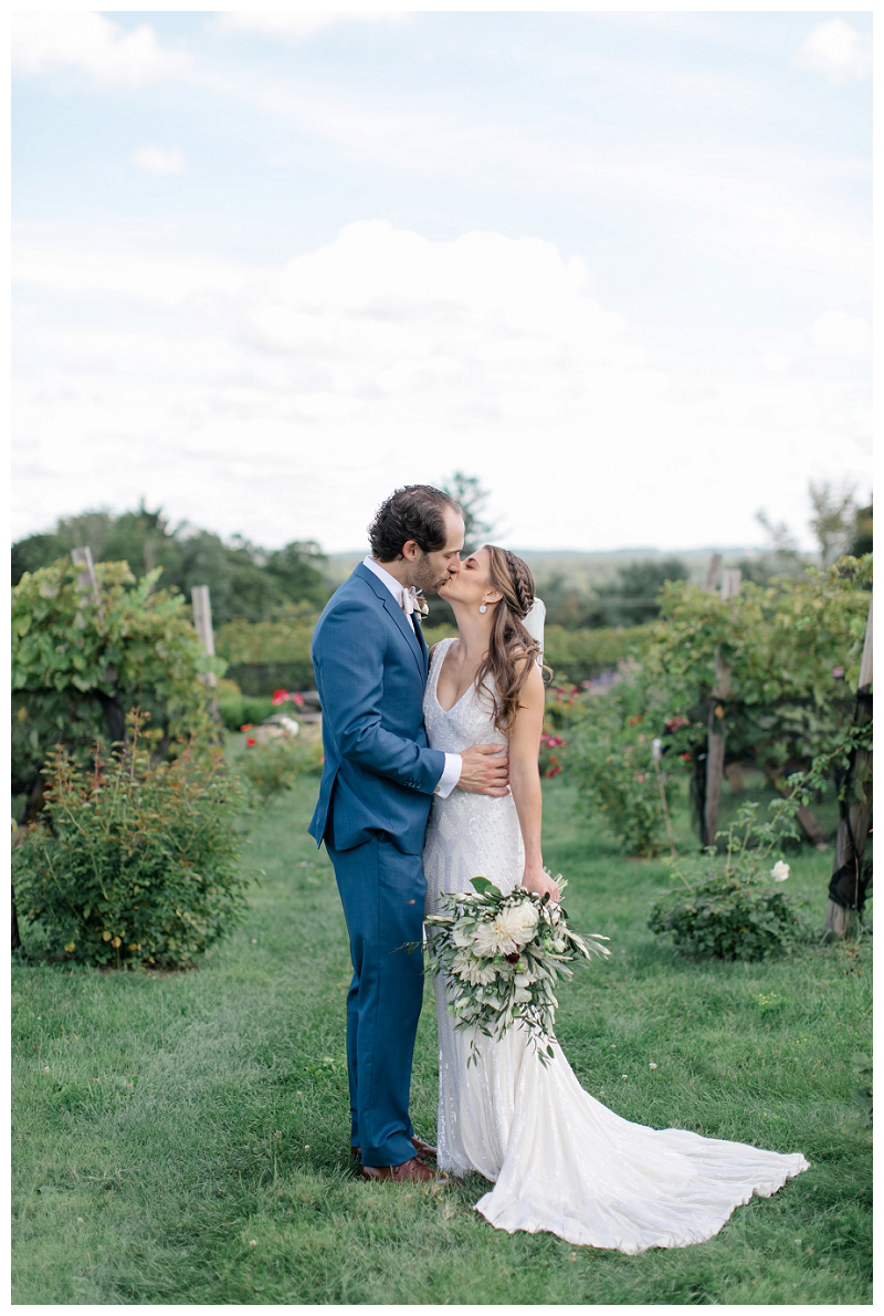 bride and groom kiss in vineyards
