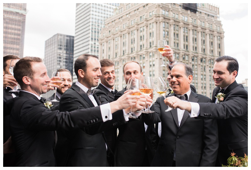 groom and groomsmen toast on nyc balcony