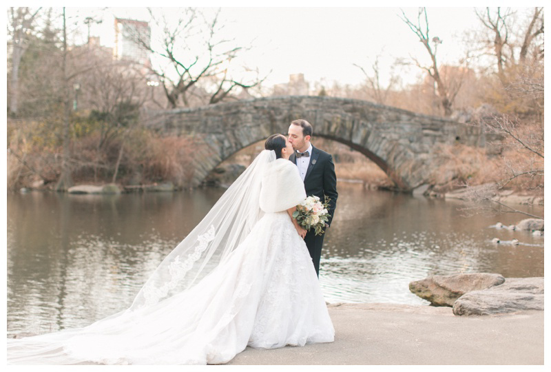 bride and groom kiss in central park after nyc winter wedding