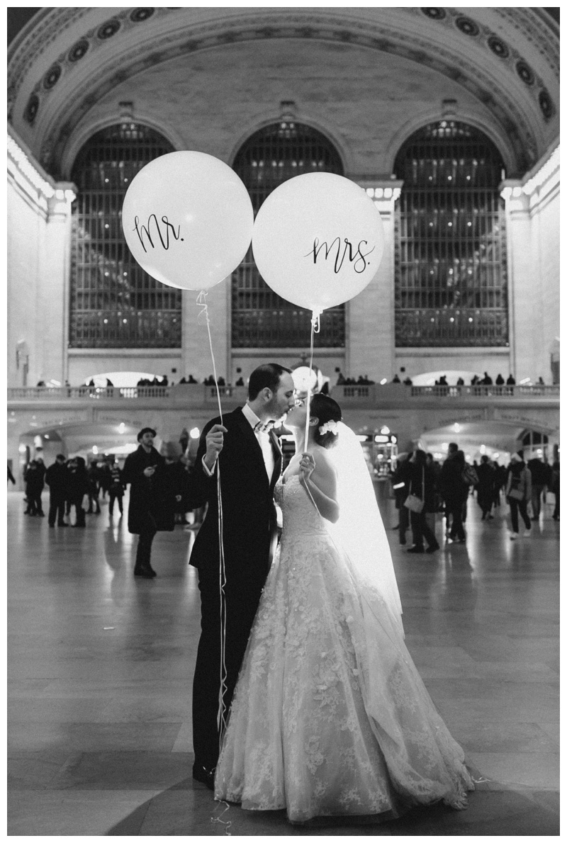 bride and groom with balloons in black and white grand central station wedding photo